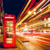 Long-exposure street photo with a telephone booth in the foreground